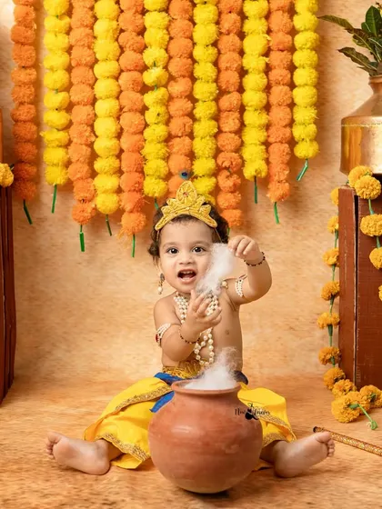 This little Krishna is having fun with a pot that seems to be smoking, adding a touch of magic to the Janmashtami shoot.