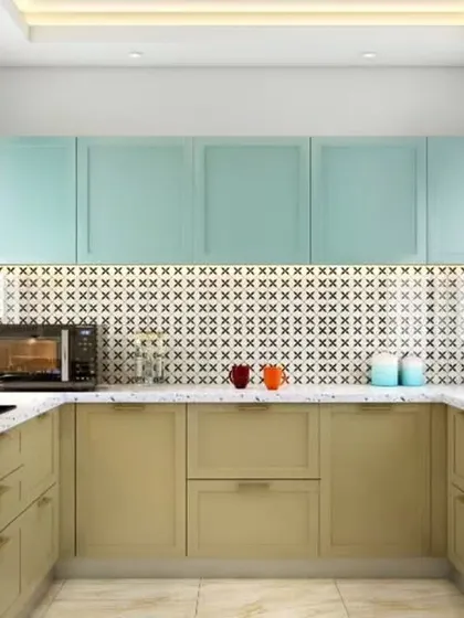A playful and vibrant U-shaped kitchen with mint green upper cabinets and beige lowers. The patterned backsplash adds a unique personality, while the terrazzo countertop provides a durable and stylish work surface.