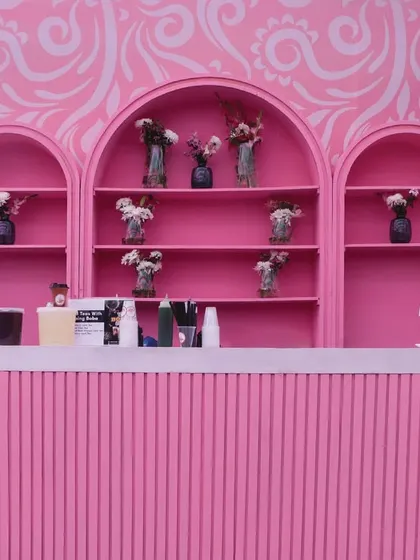 A chic all-pink bar setup with modern arches and a subtle damask pattern, serving as a stylish focal point.