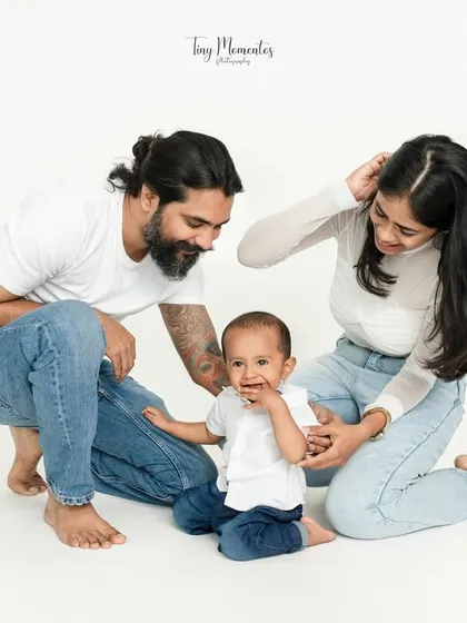 A playful moment on the floor. Getting down on the child's level often results in the most genuine smiles and interactions, as seen in this candid family portrait.