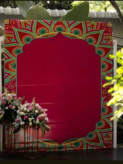 This backdrop features a rich red fabric with a traditional Indian arch pattern. It's a bold and elegant option that provides a wonderful frame for photos.