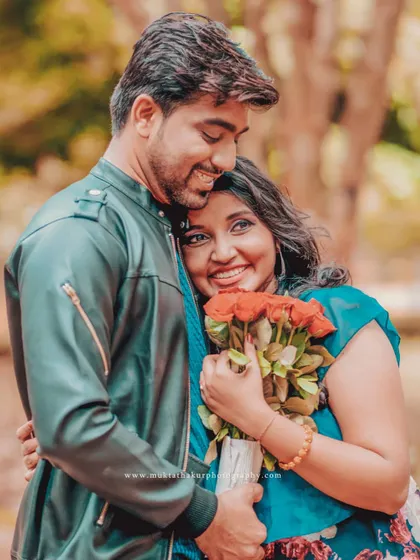The moment after the surprise. A warm embrace and a bouquet of red roses make for a perfect, heartfelt portrait.