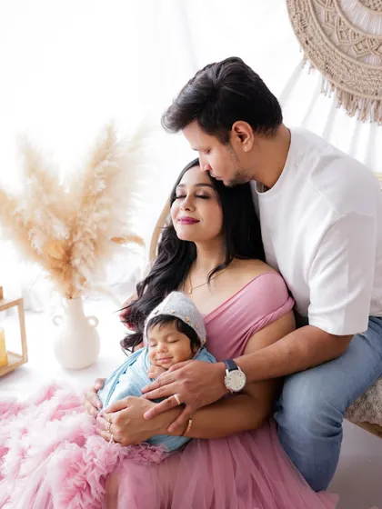 From a family of two to a family of three. This beautiful portrait captures the new parents adoring their newborn baby, a precious first family photo.