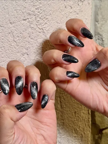 The silver magnetic streak in this black cat-eye polish gives the nails incredible dimension and a touch of mystery.