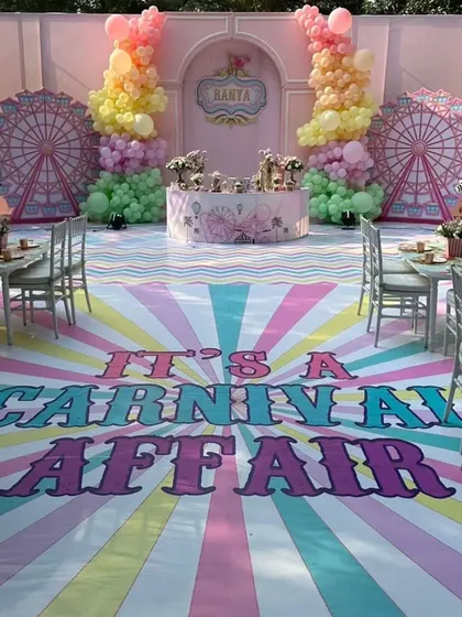 A spectacular pastel carnival party. The custom-printed floor, ferris wheel backdrops, and elaborate cake table create a stunning and immersive experience.
