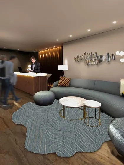 A 3D render of the reception area for the Town Palace Inn hotel. The design features a curved sofa, an organic-shaped rug, and a modern sculptural light fixture, all working together to create a fluid, contemporary, and welcoming space for guests.