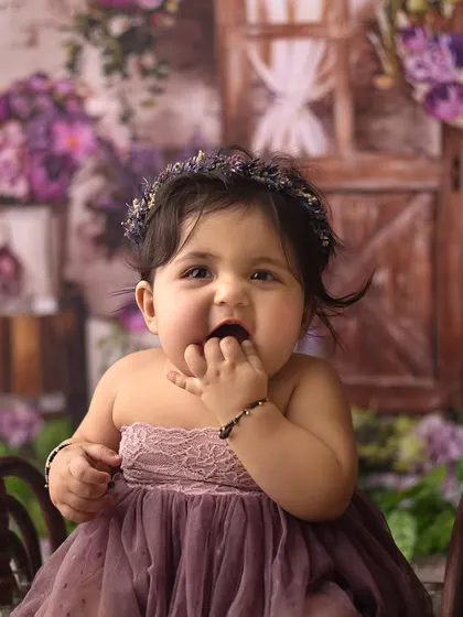 How breathtaking is this little beauty? Her curious expression and adorable cheeks are just overloaded with cuteness in this floral setting.