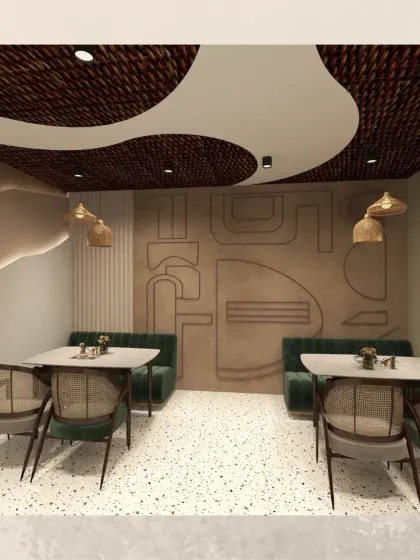 This area features booth seating with green upholstery, set against a wall with abstract, geometric reliefs. The design adds another layer of texture and artistry to the space.