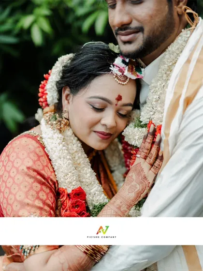 A tender and emotional close-up of a bride resting her head on her groom's chest, a beautiful candid moment.