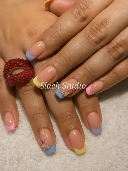 Another view of the popular pastel French tips, showing how the colors work together. The accent nails feature tiny floral details for an extra touch of personality.