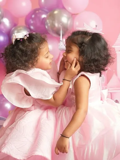 A tender moment of sisterly affection, captured forever in their magical pink kingdom.