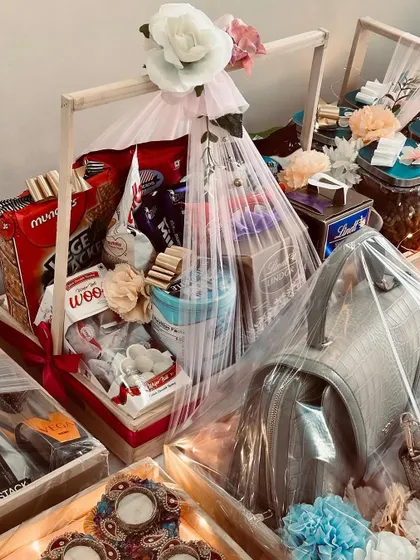 A wide view of a complete trousseau setup. It includes hampers for snacks, accessories, and outfits, all wrapped and ready for the celebration.