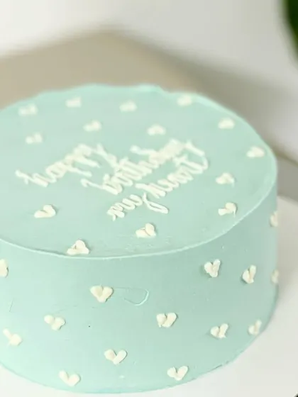 A minimalist and modern romantic cake. This light blue cake with tiny white hearts and the message "happy birthday my heart" is sweet and personal.