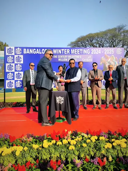 Mr. P. Ashwin Pai presents The Century Valentine's Million trophy to the winning connections of Ravishing Beauty.
