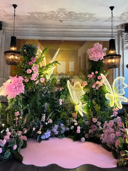A wider view of the neon butterfly floral backdrop, showing how it transforms the corner of the room into a magical photo zone.