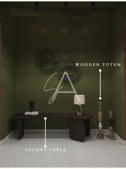 An accent table and wooden totems are displayed against an olive green wall. This setup demonstrates how to use color and sculptural elements to create a focal point in a room.