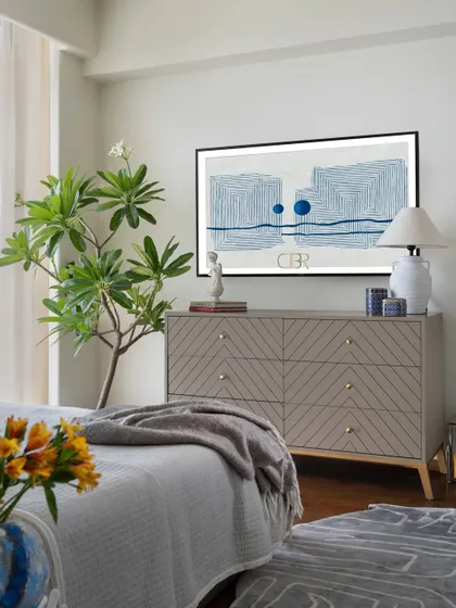 In the guest bedroom, I focused on creating visual calm with a textured chest of drawers and abstract art. The inclusion of a live plant and soft lighting makes the space feel alive and grounded, embodying the principle of meaningful minimalism.
