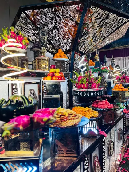 The artistic fruit display, featuring exotic fruits like dragon fruit and carefully arranged apples.