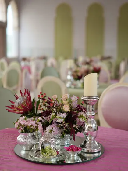 An elegant hi-tea table setting inspired by the pastel colors of Patrika Gate in Jaipur. The silver candelabras and delicate floral centerpieces created a sophisticated welcome for the groom's family.