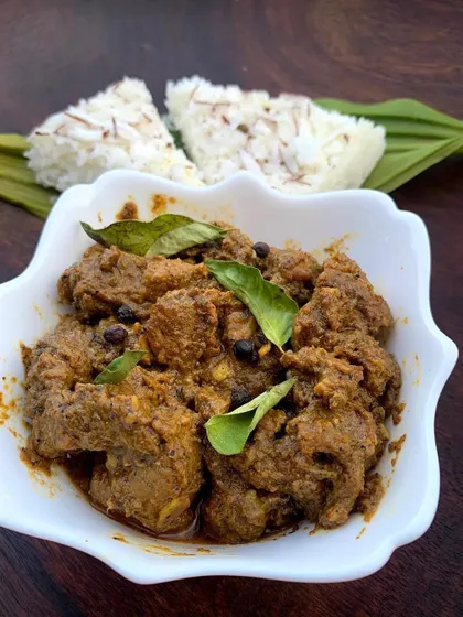 Our classic Pandi Curry served with sannas, the soft, fluffy steamed rice cakes that are perfect for soaking up every last bit of the flavorful gravy.