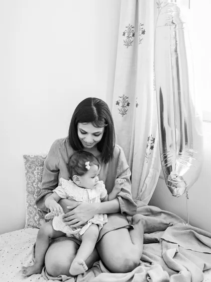 A quiet moment between a mother and her one-year-old daughter. The simplicity of this black and white image, with the "1" balloon in the background, makes it a classic and elegant milestone portrait.