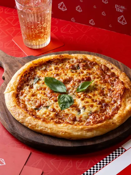 A classic Margherita pizza on a red background. This shot is a great example of clean, effective menu photography for pizzerias.