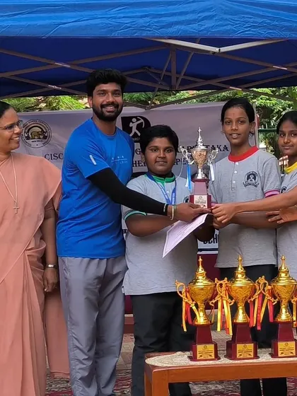 The rewards of dedication. Our students and I pose with the impressive collection of trophies won at the ICSE Regional Tournament, a testament to their skill and commitment.