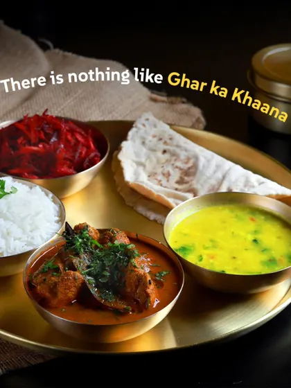 There is nothing like Ghar ka Khaana. This beautifully plated meal with chicken curry, dal, rice, bhakri, and salad says it all.