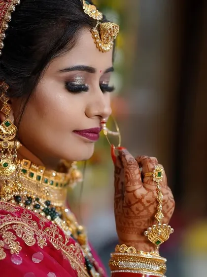 A detailed bridal portrait capturing the bride's serene expression and intricate details. We focus on beautiful close-ups that highlight the makeup, jewelry, and delicate henna, preserving the elegance of the moment.