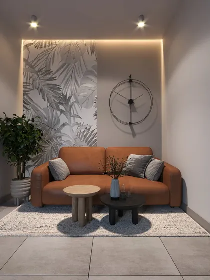 A cozy seating nook in a Kannur residence. The space is designed with a comfortable leather sofa, a monochrome botanical wallpaper, and simple nested coffee tables.