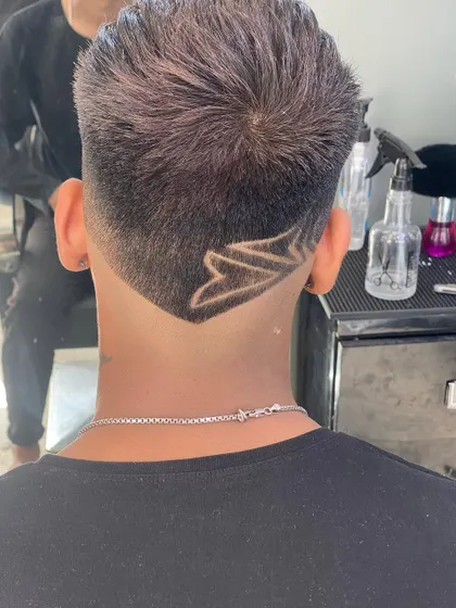A view from the back, showing a V-shaped neckline with a custom geometric design. This style creates a sharp and clean finish to the haircut.