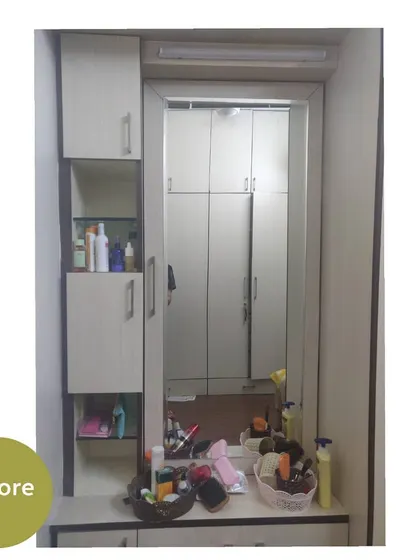 The dressing table unit before we started. The countertop and shelves are cluttered with various products.