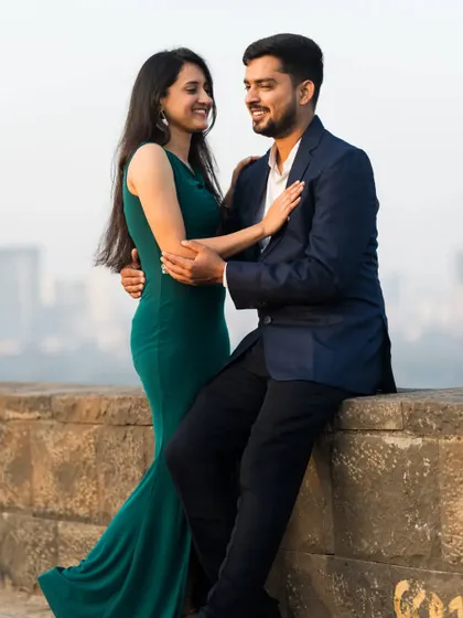 A romantic pre-wedding shot with the city skyline in the background, capturing an intimate moment between the couple.