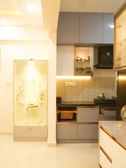 An open and bright living space where the kitchen's breakfast bar and crockery unit are visible. The design promotes social interaction and a sense of spaciousness.