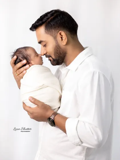 A father's gentle touch. This close-up shot captures the tender connection between a dad and his newborn baby.