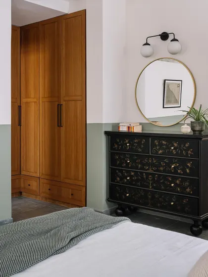 A hand-painted chest of drawers adds an artistic and bespoke touch to this bedroom, showing how furniture can be both functional and a piece of art.