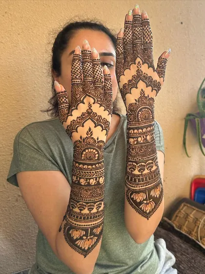 A unique design with large lotus motifs at the base of the arm and delicate patterns on the hands and fingers.