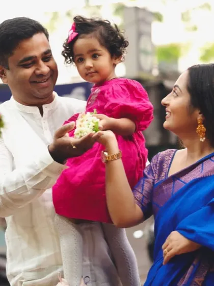 A sweet family moment among the flowers. The parents share a loving moment with their daughter, surrounded by the colors and life of the market.