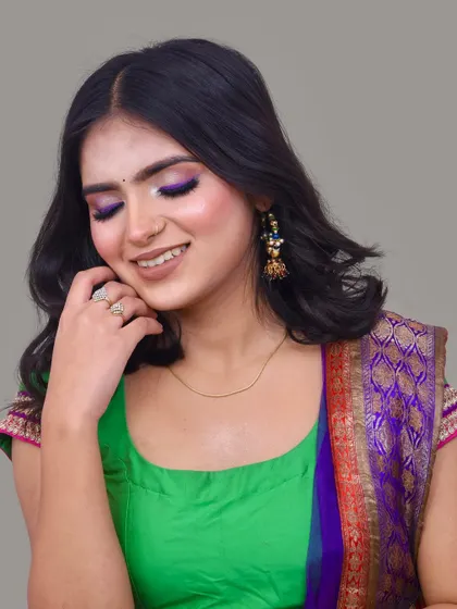 Another angle of the purple and green saree look, showing how the makeup catches the light.