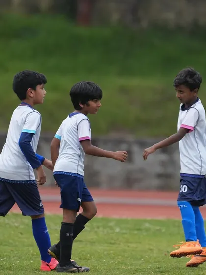 Players communicating and working together during a match. Teamwork is the cornerstone of our philosophy.