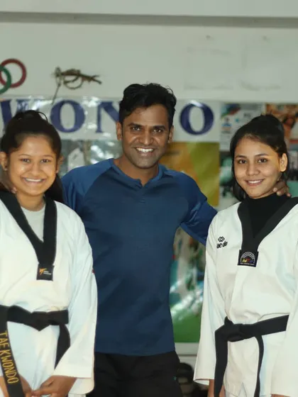 Posing with two of my black belt students in our dojang. I work closely with advanced students to refine their technique and prepare them for leadership roles.