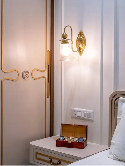 A detail shot of the vintage-style brass wall sconce and the custom wardrobe handle, showcasing our attention to period-appropriate hardware and lighting.
