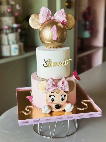 Big bow, big smiles! This tall Minnie Mouse cake is party-ready, featuring a giant golden bow topper and a peek-a-boo Minnie for a touch of Disney magic.