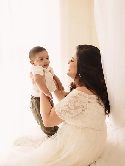 A mother's playful lift, full of laughter and light. These candid moments during a milestone session show the beautiful, evolving relationship with her baby.