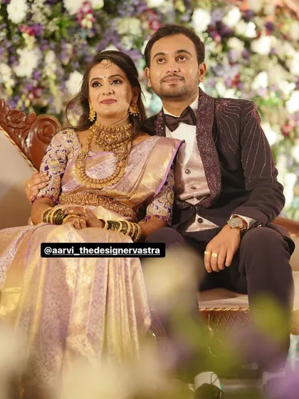The couple at their reception. The bride's lavender saree and the groom's embroidered tuxedo were designed to match perfectly.
