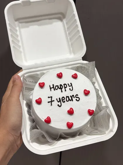 A simple and sweet bento cake to celebrate a 7-year anniversary. The minimalist design with red hearts is perfect for a romantic gesture.