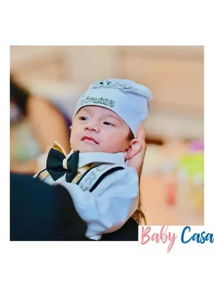 This little boy looks so handsome in his tuxedo style romper and personalized cap. It's a perfect outfit for a special occasion, combining style with the comfort a baby needs.