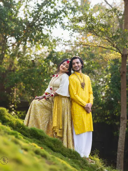 A serene portrait of a couple during their Haldi festivities, dressed in beautiful yellow outfits and surrounded by nature.