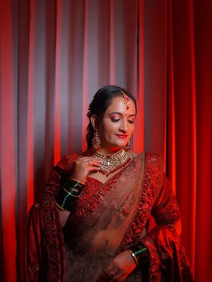 A happy client looking beautiful at her reception. She chose a classic Kundan choker set that perfectly complements her red outfit.