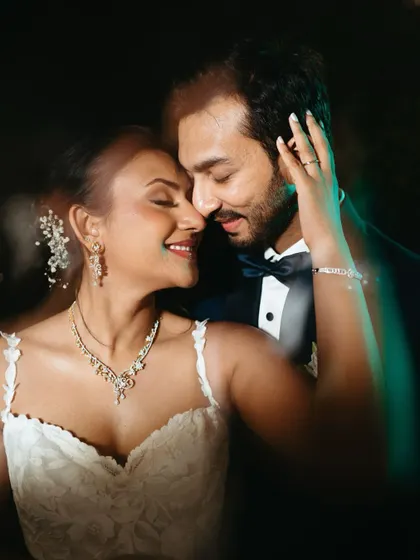 A close-up portrait from the wedding day, filled with warmth and emotion. The soft focus and subtle light flares create a dreamy, magical atmosphere around the couple as they share an intimate moment.